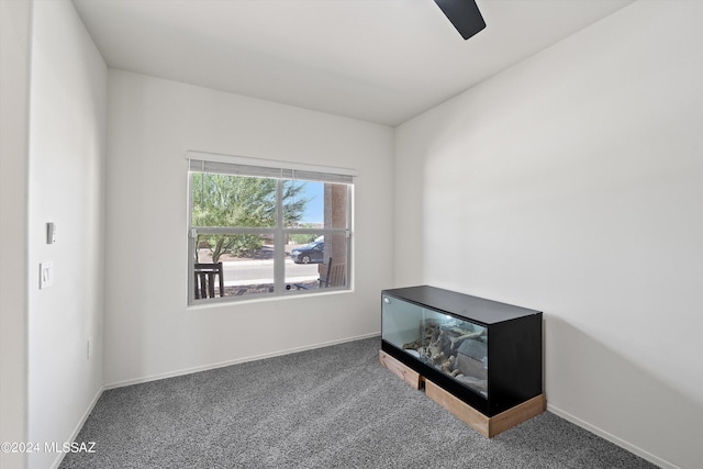 carpeted empty room featuring baseboards and ceiling fan