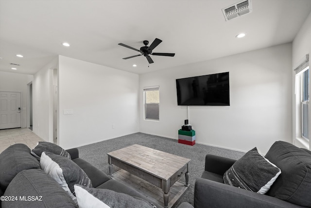 carpeted living room with ceiling fan