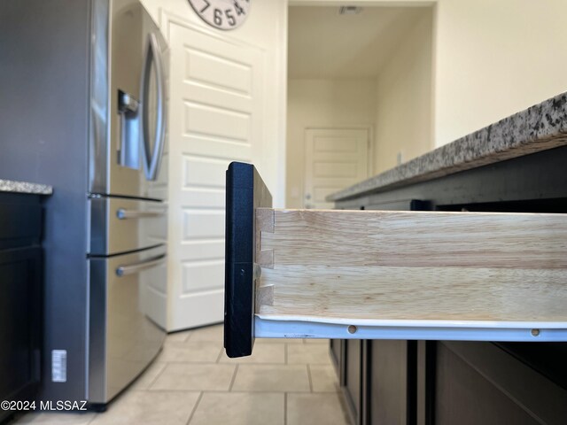 kitchen featuring light tile patterned flooring and stainless steel refrigerator with ice dispenser