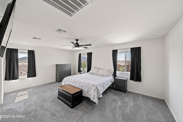 carpeted bedroom featuring baseboards, ceiling fan, and visible vents