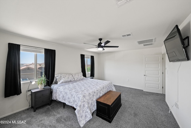 bedroom featuring multiple windows, dark carpet, and visible vents