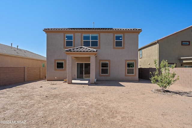 back of house featuring a fenced backyard, a tile roof, stucco siding, and a patio area