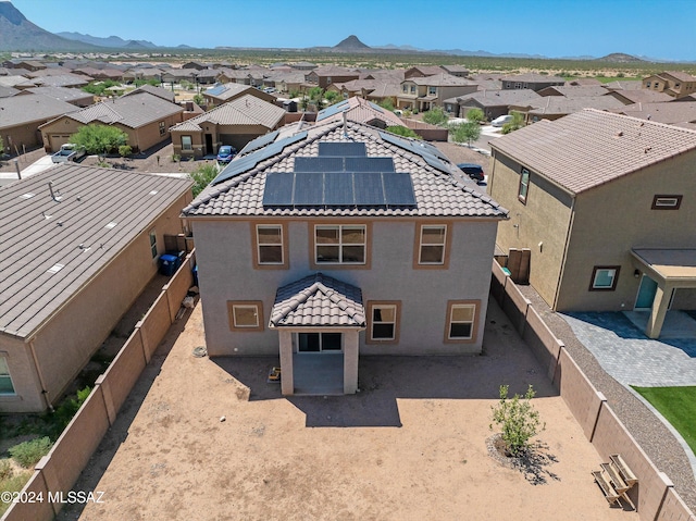 exterior space with a tile roof, a mountain view, a fenced backyard, and a residential view