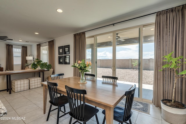 tiled dining space with ceiling fan and a water view