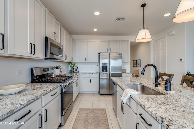 kitchen with stainless steel appliances, white cabinetry, and hanging light fixtures