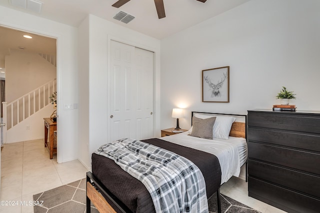 bedroom with ceiling fan, tile patterned flooring, and a closet