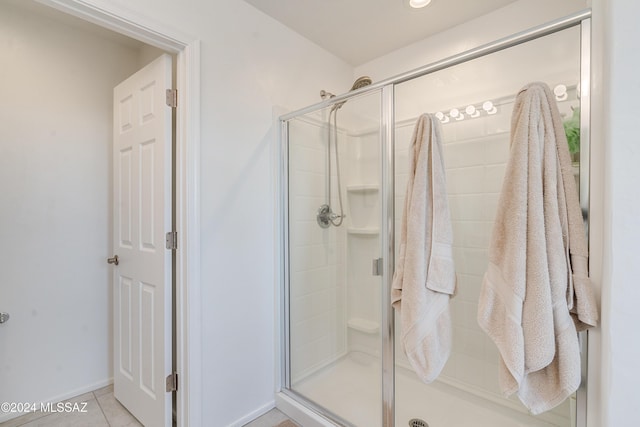 bathroom featuring a shower with shower door and tile patterned floors