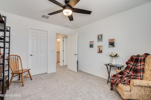 living area featuring ceiling fan and light colored carpet