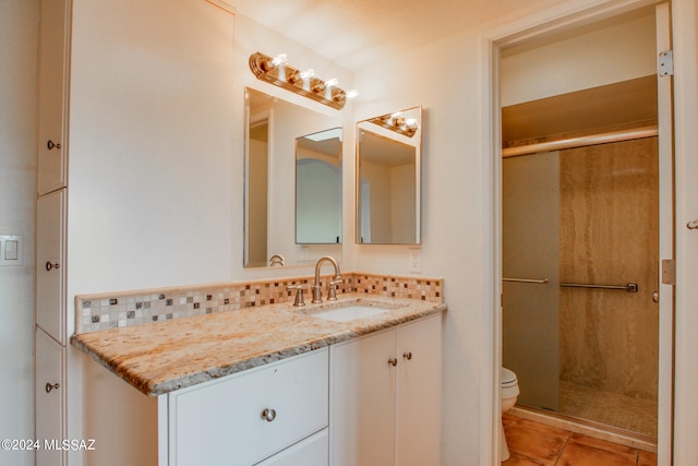 bathroom with decorative backsplash, vanity, tile patterned flooring, toilet, and an enclosed shower