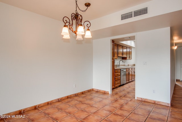 spare room with light tile patterned floors, sink, and a chandelier