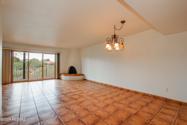 spare room featuring an inviting chandelier and light tile patterned flooring