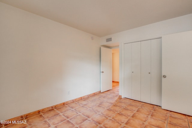 unfurnished bedroom with a closet and light tile patterned floors