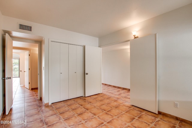 unfurnished bedroom featuring a closet and light tile patterned floors