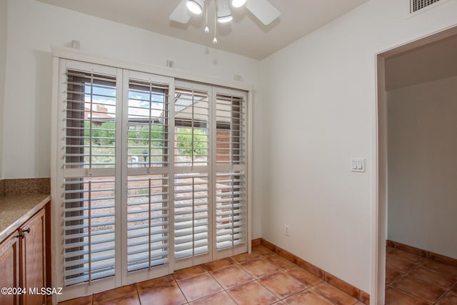 tiled spare room featuring ceiling fan