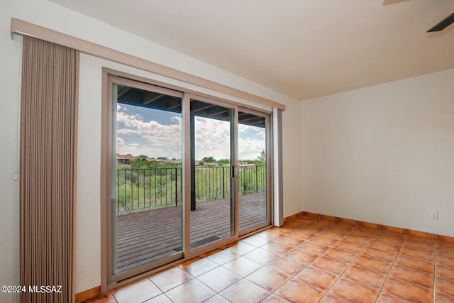 spare room with ceiling fan and light tile patterned floors