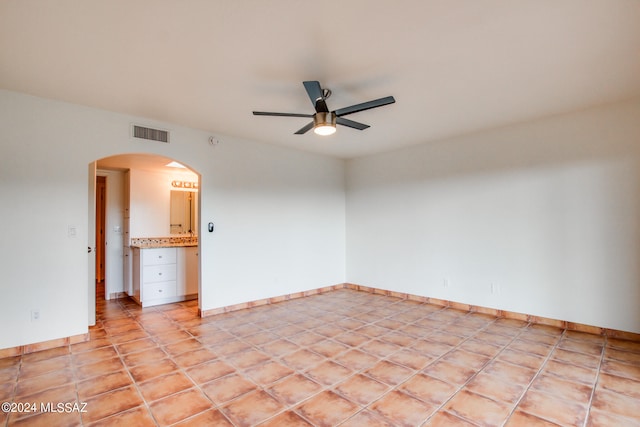 tiled empty room featuring ceiling fan