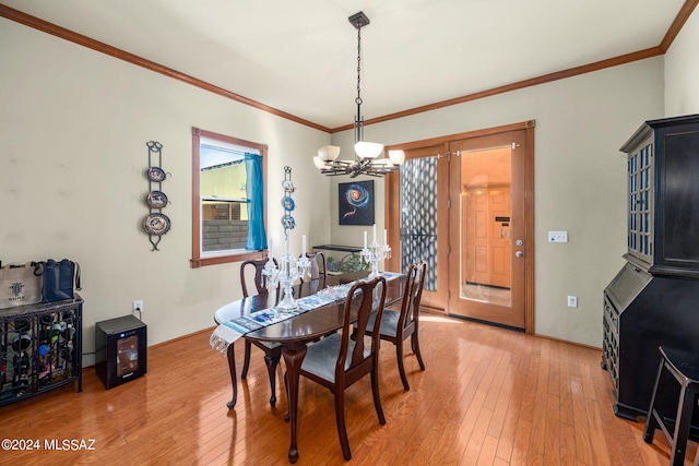 dining area with ornamental molding, hardwood / wood-style flooring, and an inviting chandelier