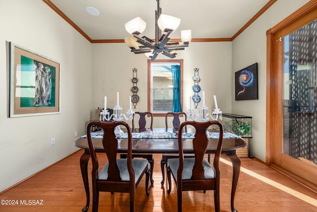 dining room with ornamental molding, hardwood / wood-style flooring, and a notable chandelier