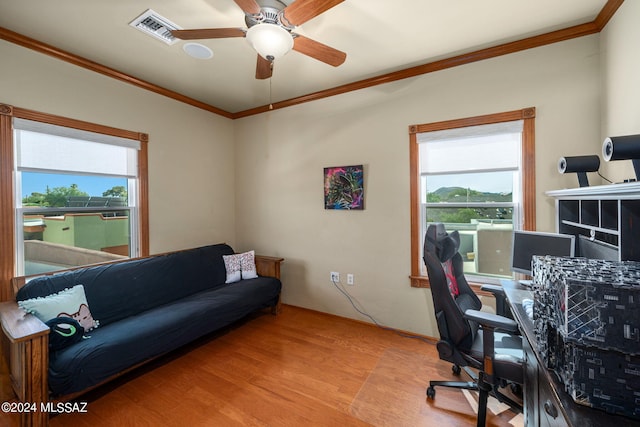 office area with ceiling fan, a wealth of natural light, ornamental molding, and light hardwood / wood-style flooring