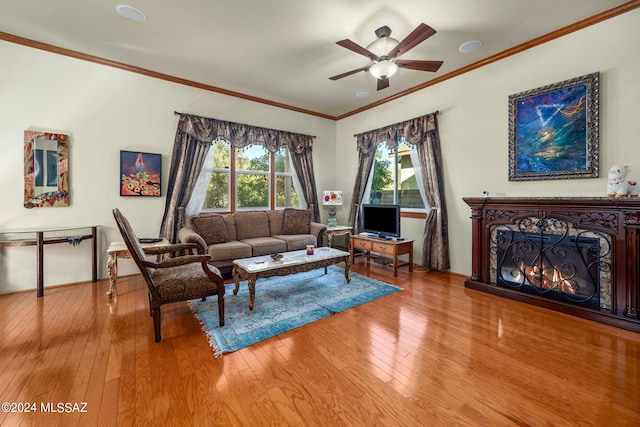 living room featuring wood-type flooring, crown molding, and ceiling fan