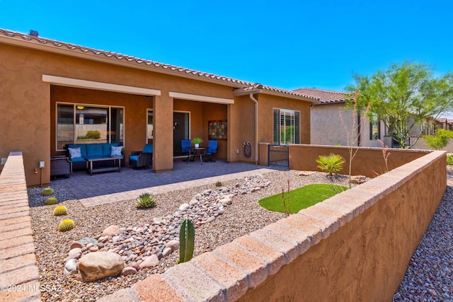 back of property with outdoor lounge area and a patio area