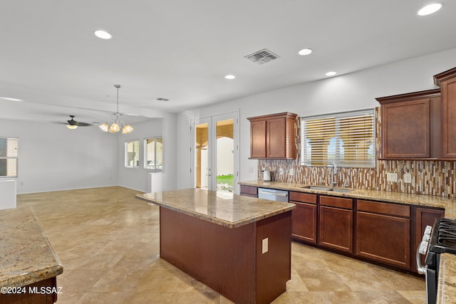 kitchen with a wealth of natural light, a kitchen island, hanging light fixtures, and backsplash