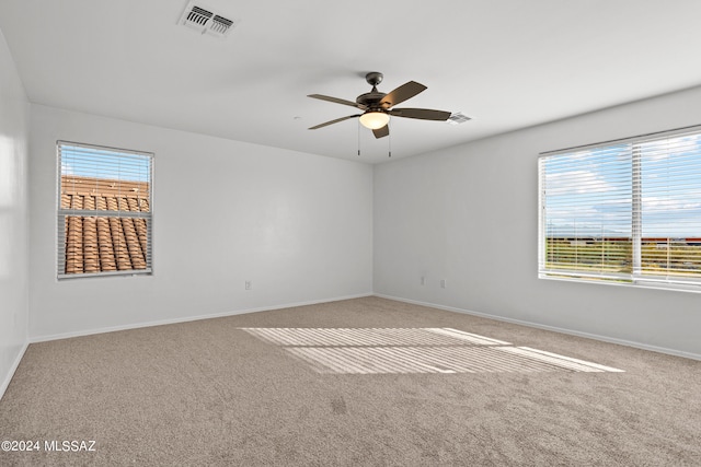 carpeted spare room with ceiling fan