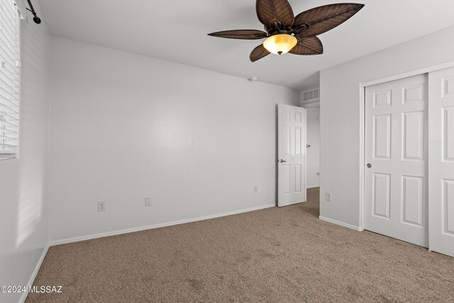 unfurnished bedroom with ceiling fan, a closet, and carpet floors