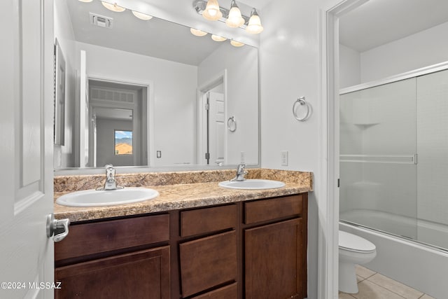 full bathroom featuring shower / bath combination with glass door, vanity, toilet, and tile patterned floors