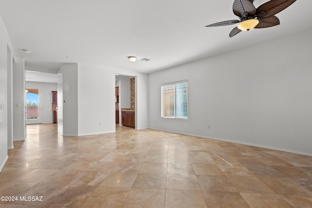 empty room with visible vents, baseboards, and a ceiling fan