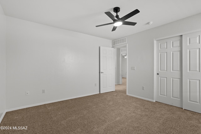 unfurnished bedroom featuring carpet, ceiling fan, and a closet