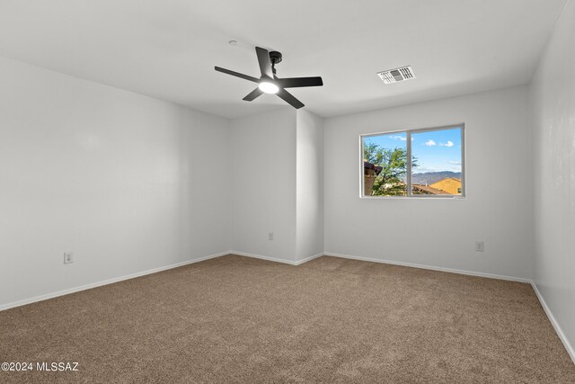 carpeted spare room with ceiling fan