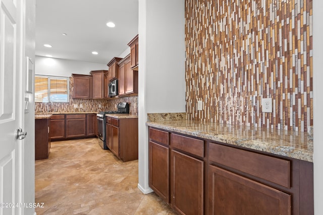 kitchen with light stone countertops, stainless steel appliances, and decorative backsplash