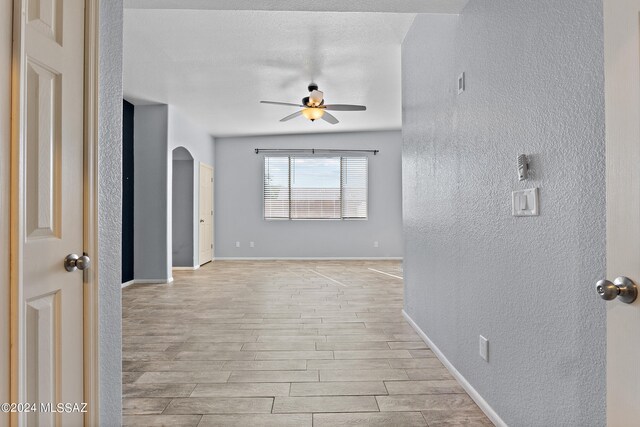 interior space featuring lofted ceiling, light hardwood / wood-style floors, and a textured ceiling