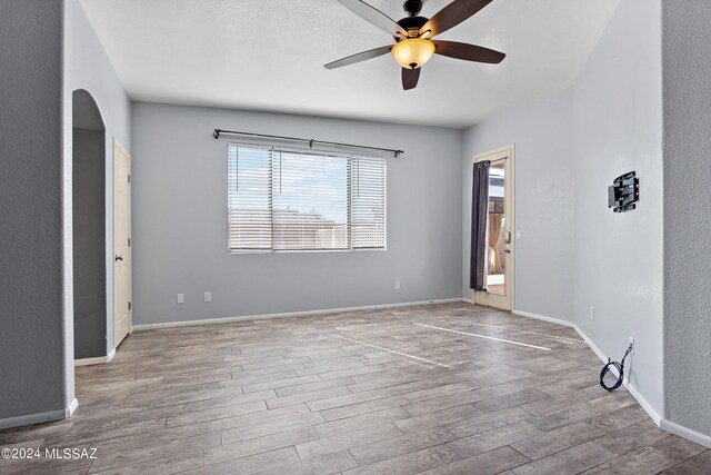 empty room with light wood-type flooring and ceiling fan