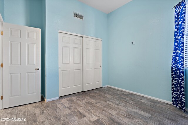 unfurnished bedroom with hardwood / wood-style floors and a closet