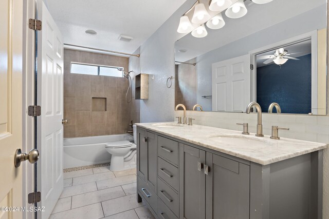 full bathroom featuring tiled shower / bath combo, tile patterned floors, ceiling fan, vanity, and toilet