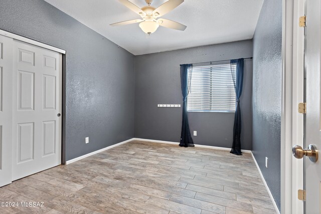 spare room with ceiling fan and light hardwood / wood-style flooring