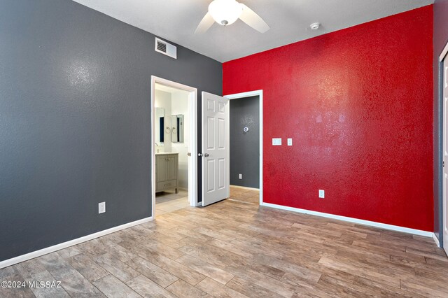 unfurnished bedroom featuring ceiling fan, hardwood / wood-style flooring, and ensuite bath