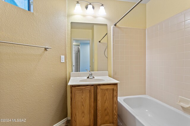 bathroom featuring vanity and tiled shower / bath