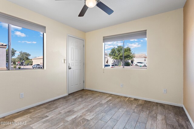 spare room with ceiling fan and light wood-type flooring