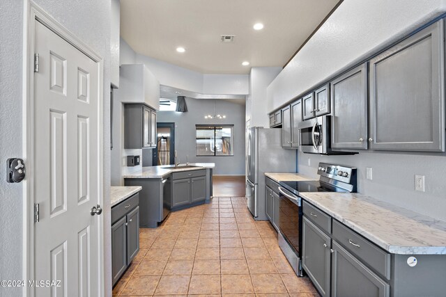 kitchen featuring gray cabinetry, sink, light tile patterned floors, and stainless steel appliances