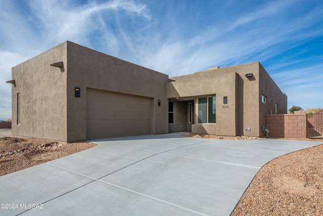 pueblo-style house featuring a garage