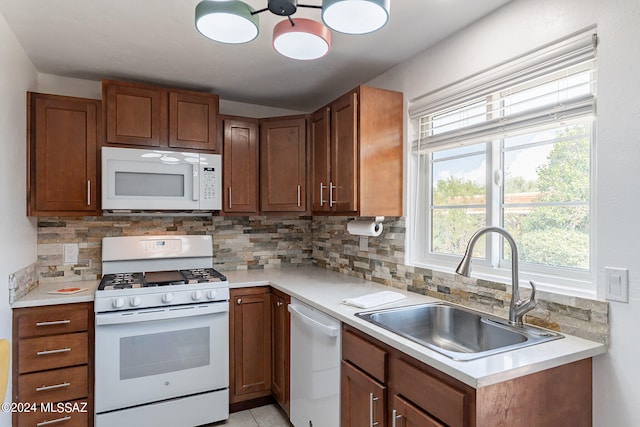 kitchen with backsplash, sink, and white appliances