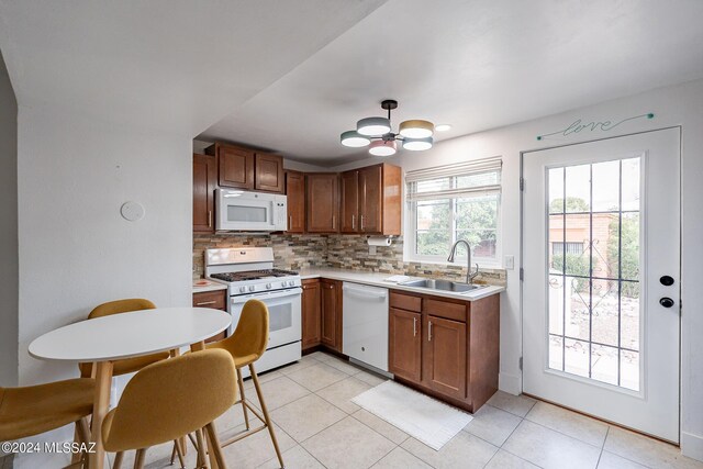 kitchen featuring light tile patterned floors, sink, white appliances, and decorative backsplash