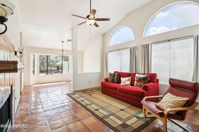 living room featuring ceiling fan with notable chandelier, tile patterned flooring, and high vaulted ceiling