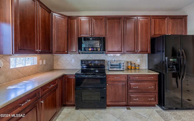 kitchen featuring tasteful backsplash, light tile patterned floors, and black appliances