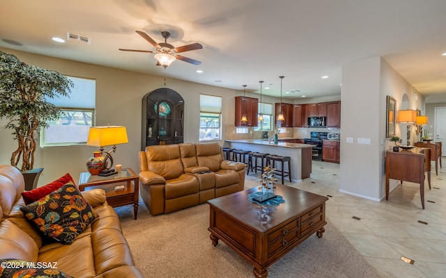 living room featuring light tile patterned floors and ceiling fan