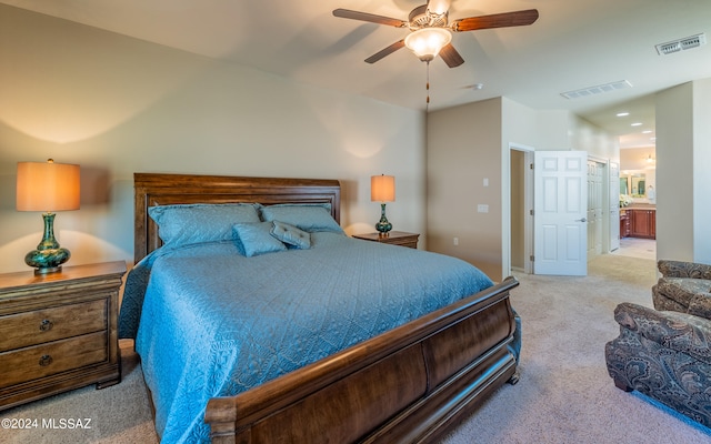 bedroom featuring ceiling fan, connected bathroom, and light carpet