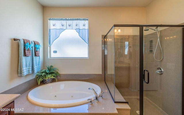 bathroom with vanity and shower with separate bathtub